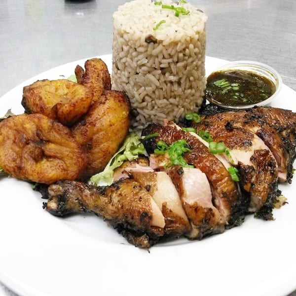 Ms. Martha's Caribbean Kitchen's jerk chicken with rice and peas, fried plantains, and a side of sauce.