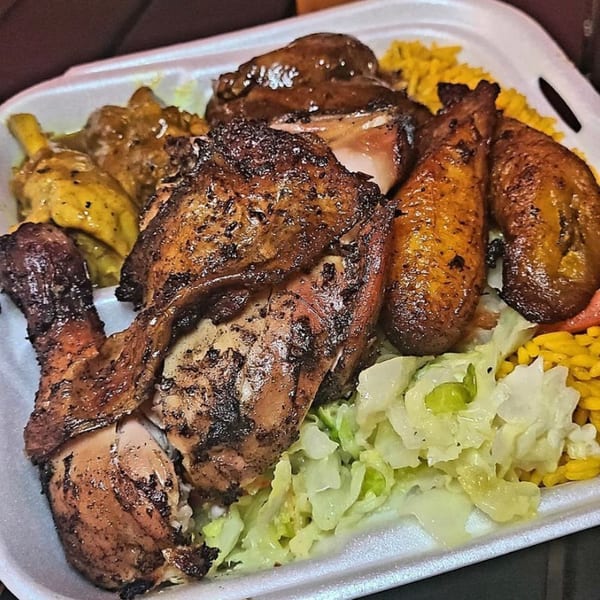 A takeout container filled with Ms. Martha's Caribbean Kitchen's jerk chicken, plantains, rice, and cabbage.